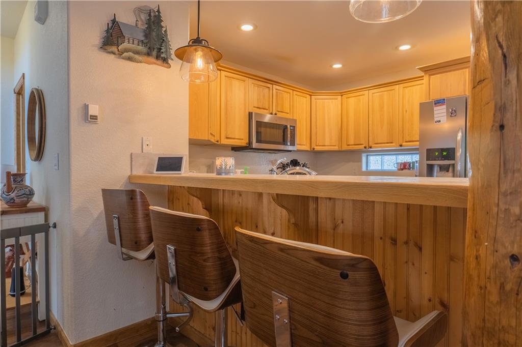 7 Lookout Ridge Drive, Unit 7 Dillon, CO 80435 - Photo 27 of 35 a kitchen with stainless steel appliances a sink cabinets and wooden floor