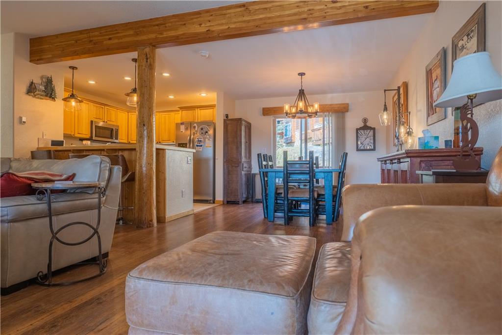 7 Lookout Ridge Drive, Unit 7 Dillon, CO 80435 - Photo 6 of 35 a living room with furniture a chandelier and a dining table with wooden floor
