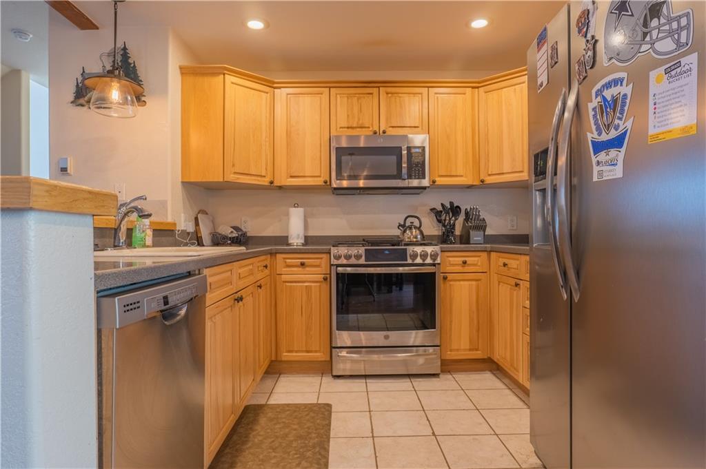 7 Lookout Ridge Drive, Unit 7 Dillon, CO 80435 - Photo 10 of 35 a kitchen with stainless steel appliances a stove a sink and a microwave