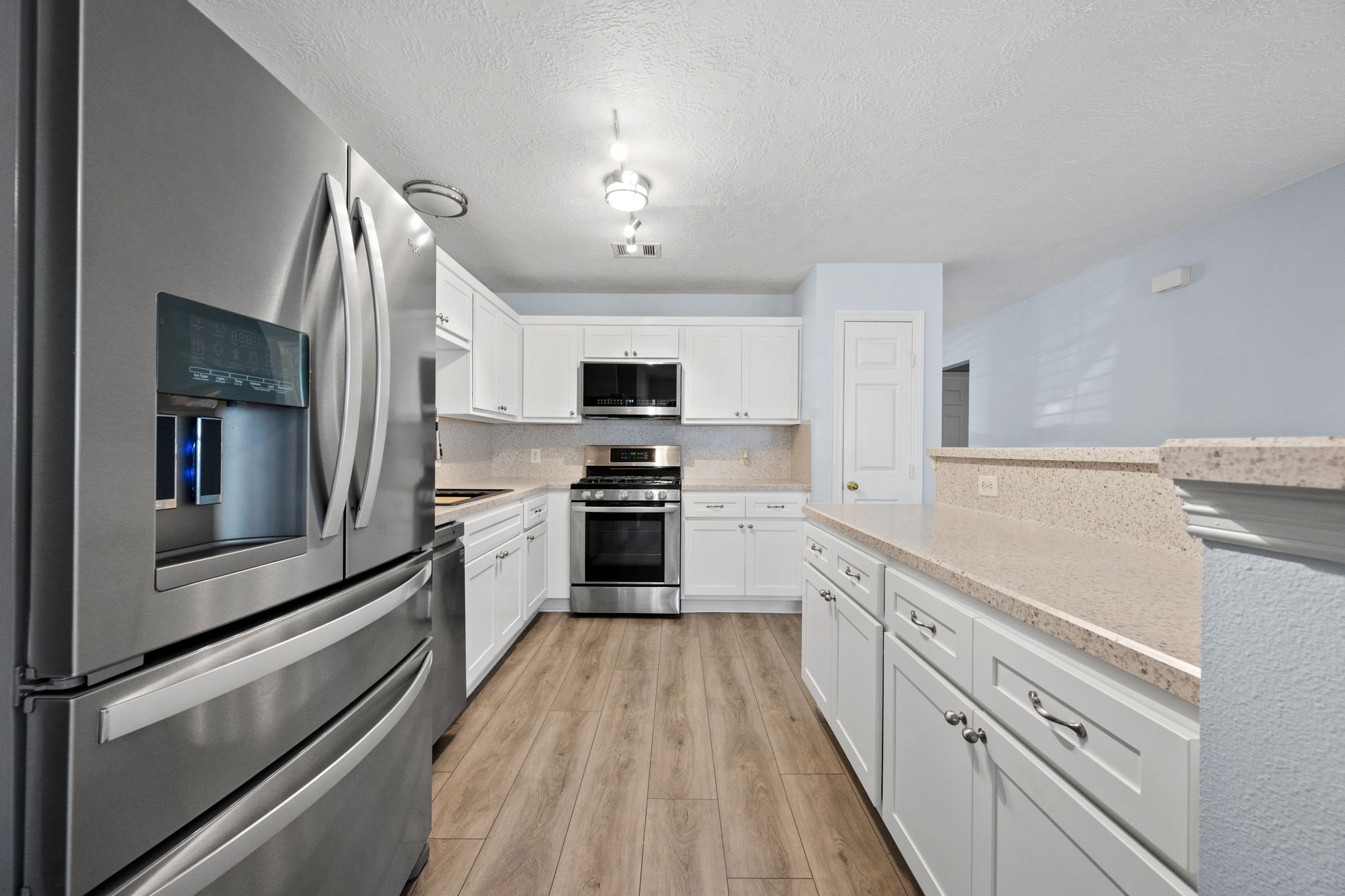 21893 Pinewilde Court Porter, TX 77365 - Photo 18 of 25 a kitchen with cabinets stainless steel appliances and wooden floor