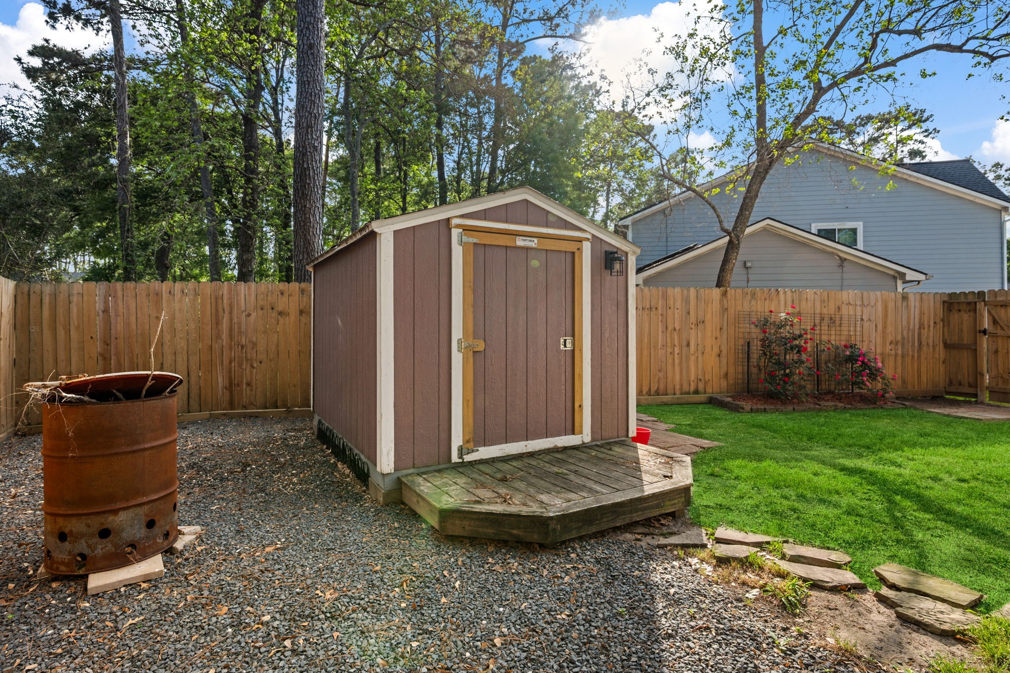 21893 Pinewilde Court Porter, TX 77365 - Photo 7 of 25 a view of a backyard with a small cabin and a chair