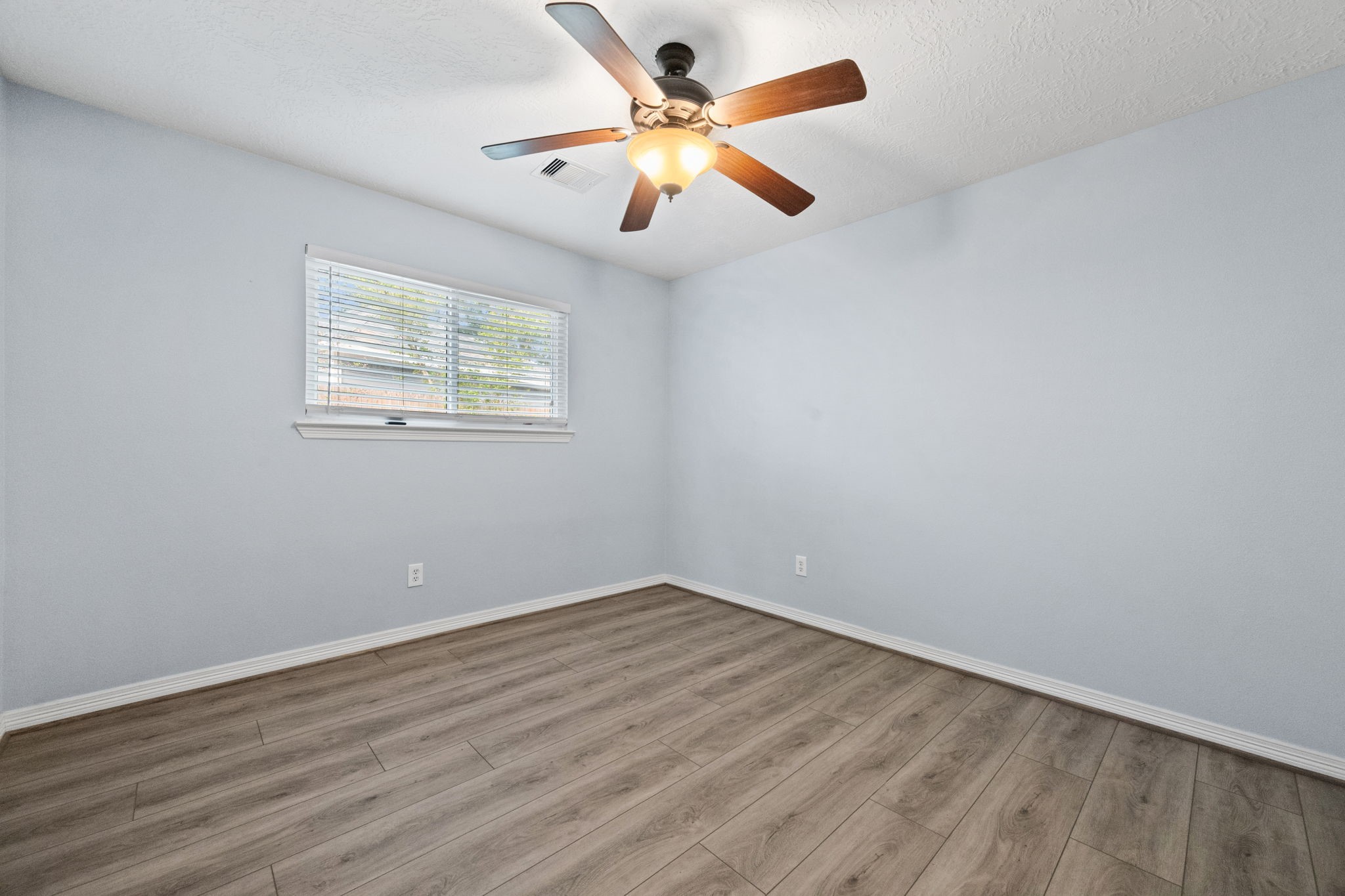 21893 Pinewilde Court Porter, TX 77365 - Photo 8 of 25 an empty room with wooden floor and ceiling fan