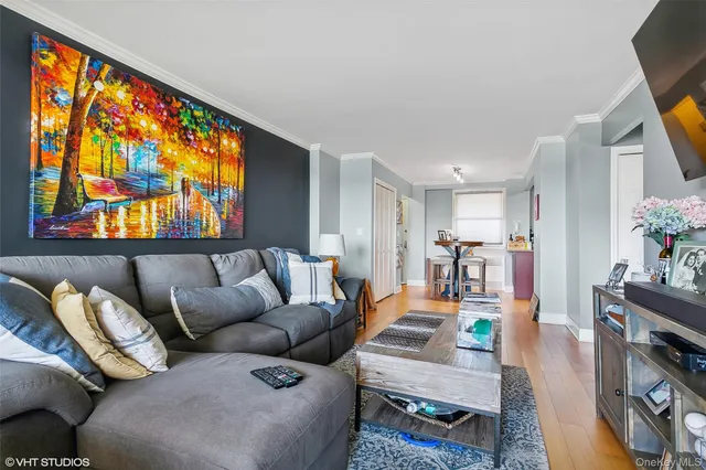 a living room with furniture a flat screen tv and a floor to ceiling window