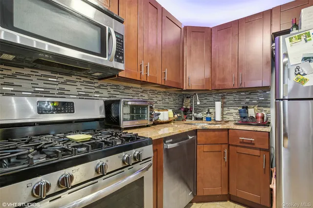 a kitchen with stainless steel appliances granite countertop a stove and a microwave