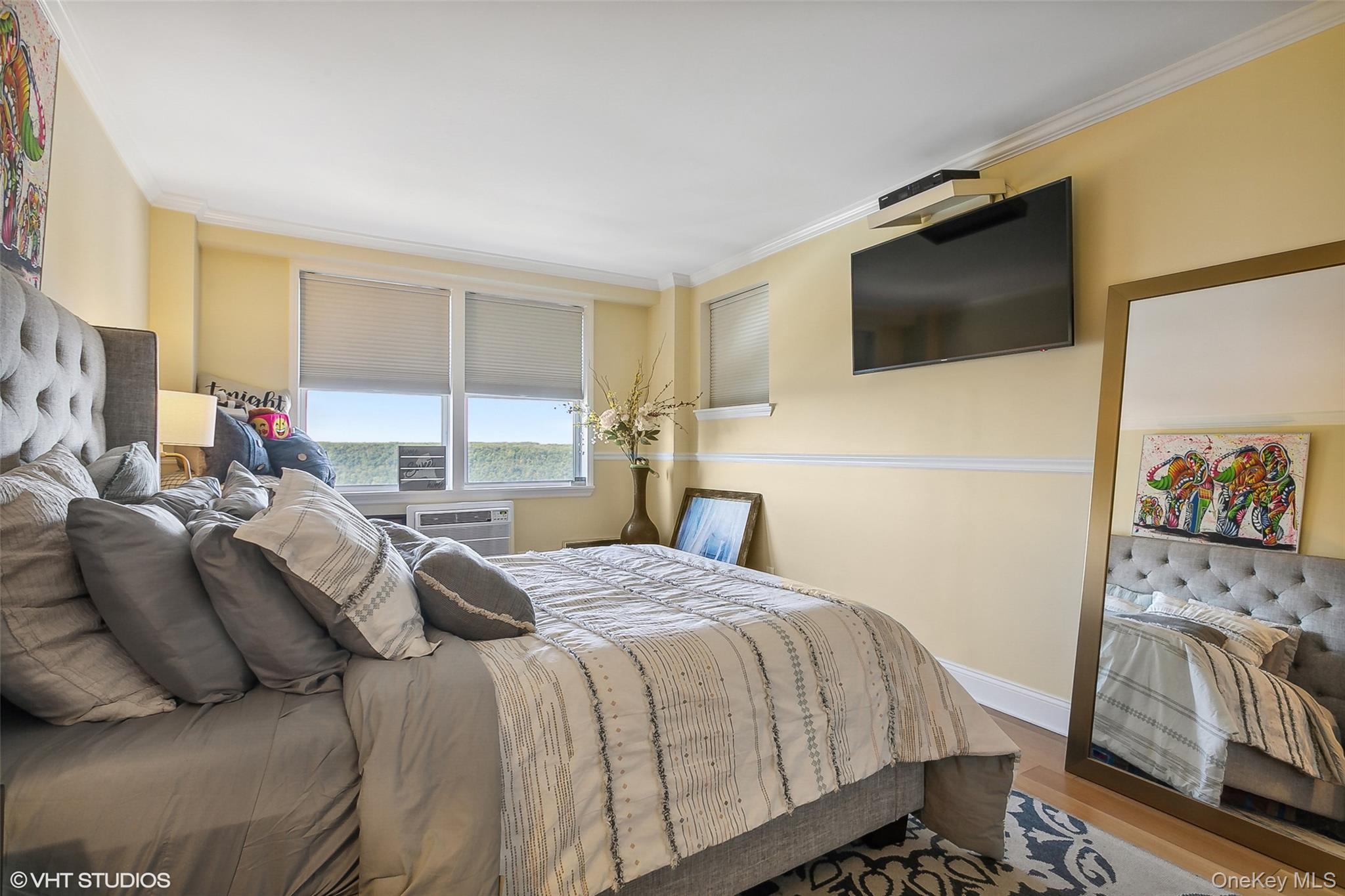 5800 Arlington Avenue, Unit 19L Bronx, NY 10471 - Photo 6 of 19 a bedroom with a bed and a flat screen tv