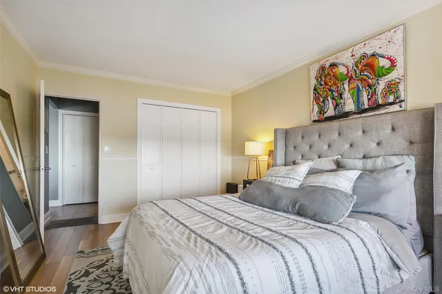 a bedroom with a bed and a painting on the wall