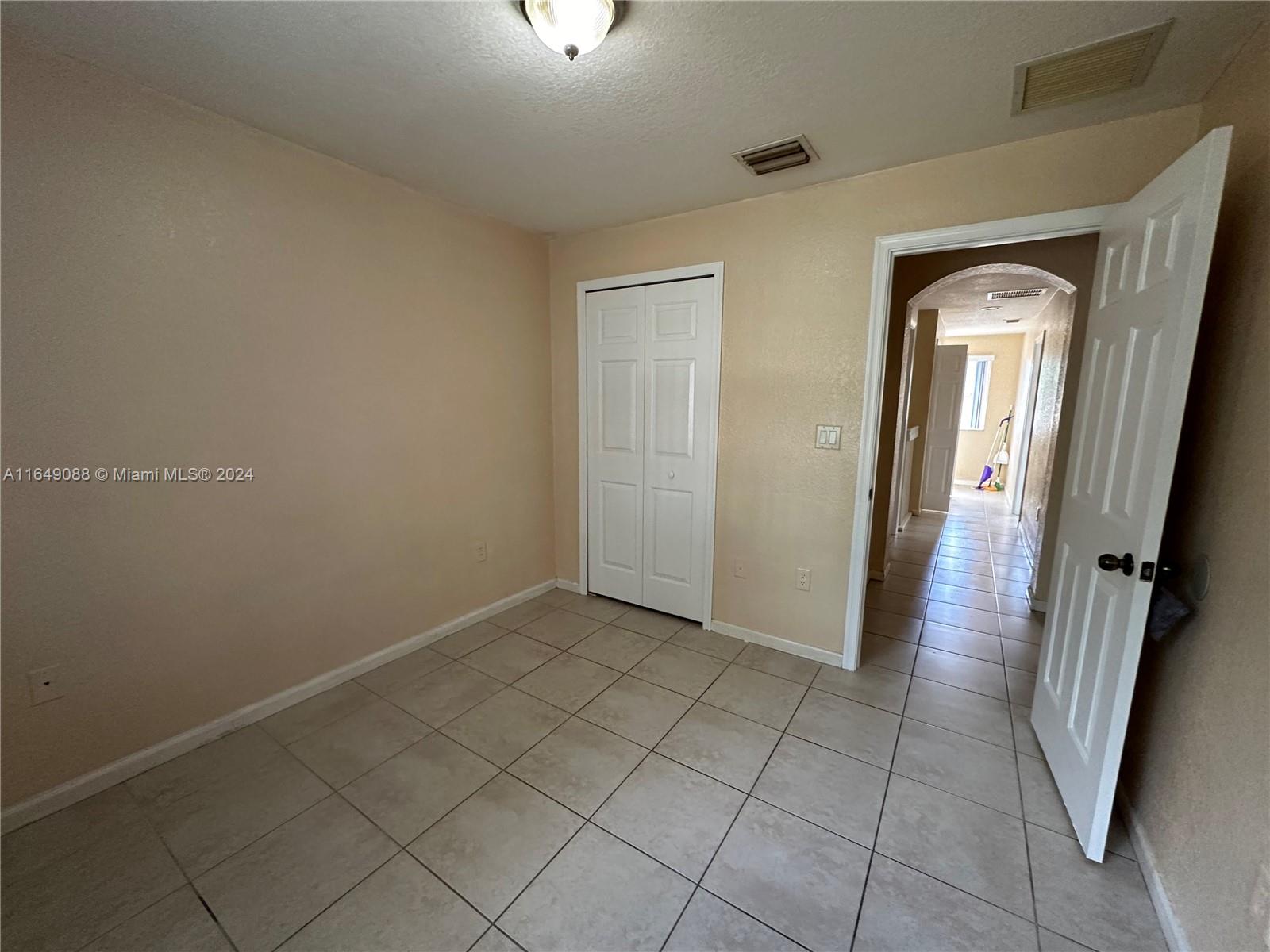 2720 Southeast 15th Road, Unit 13 Homestead, FL 33035 - Photo 2 of 5 an empty room with wooden floor and mirror
