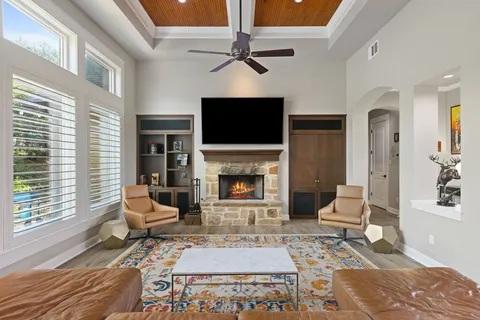 a living room with furniture a flat screen tv and a fireplace