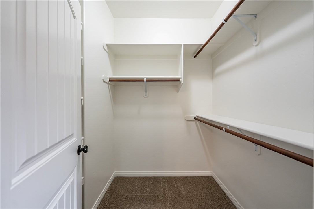 3546 North Kenneth Road Kingman, AZ 86409 - Photo 13 of 35 The property features a closet with carpeted flooring, white walls, and built-in shelving units with hanging???????????????????????????????? rods
