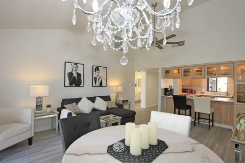 a living room with furniture or chandelier and a wooden floor