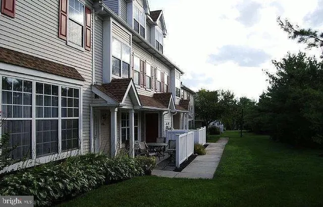 a view of a house with brick walls and a yard with plants