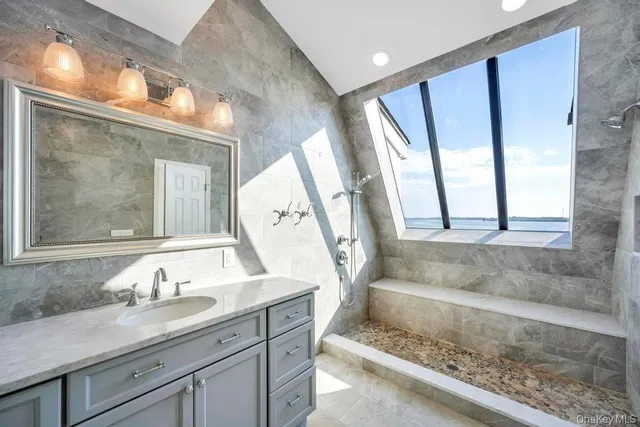 a bathroom with a granite countertop bathtub a toilet and a shower