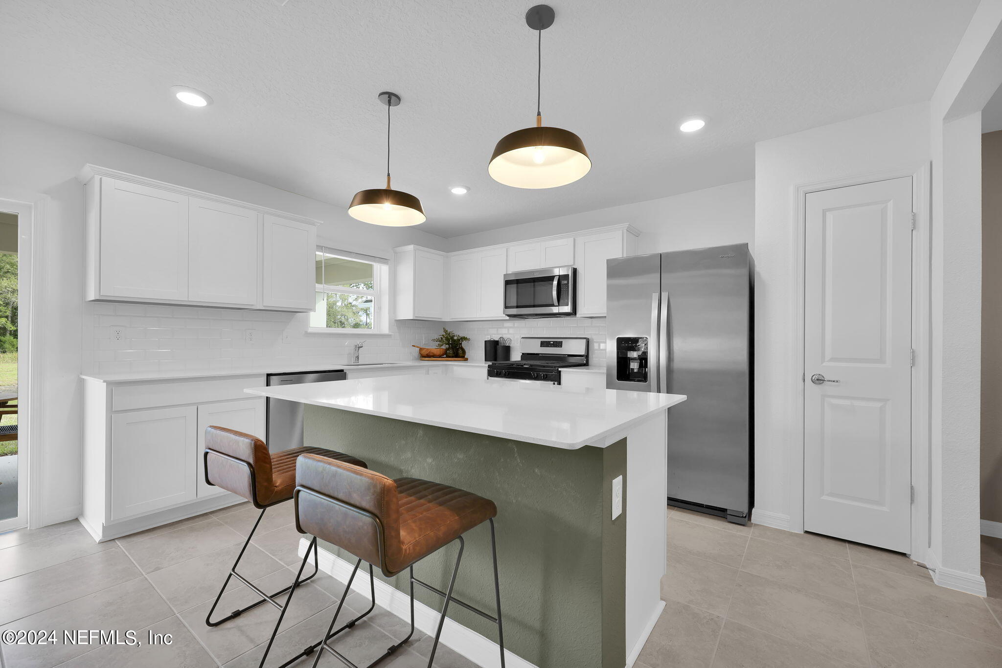 5460 Integrity Way Jacksonville, FL 32244 - Photo 9 of 31 a kitchen with stainless steel appliances kitchen island granite countertop a sink a center island a stove and a cabinets