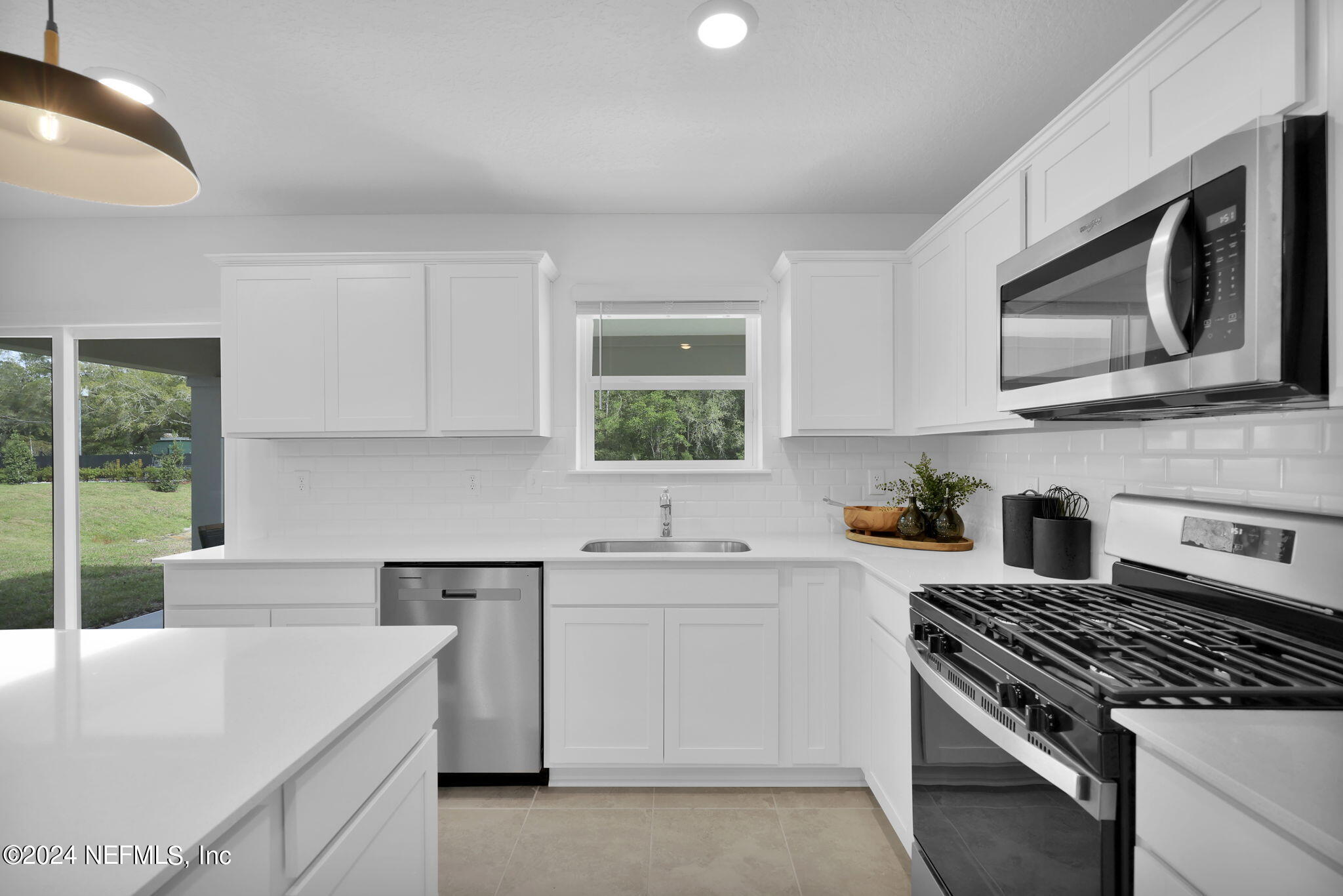 5460 Integrity Way Jacksonville, FL 32244 - Photo 10 of 31 a kitchen with stainless steel appliances white cabinets and a stove top oven