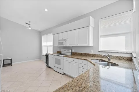 a large white kitchen with a sink and cabinets