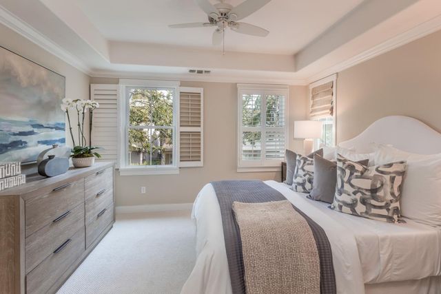 a spacious bedroom with a large bed and a chandelier