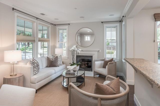 a living room with furniture fireplace and a large window