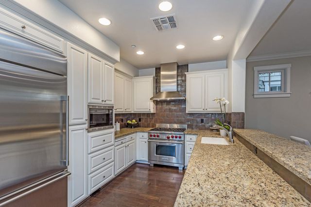 a kitchen with a stove sink and cabinets