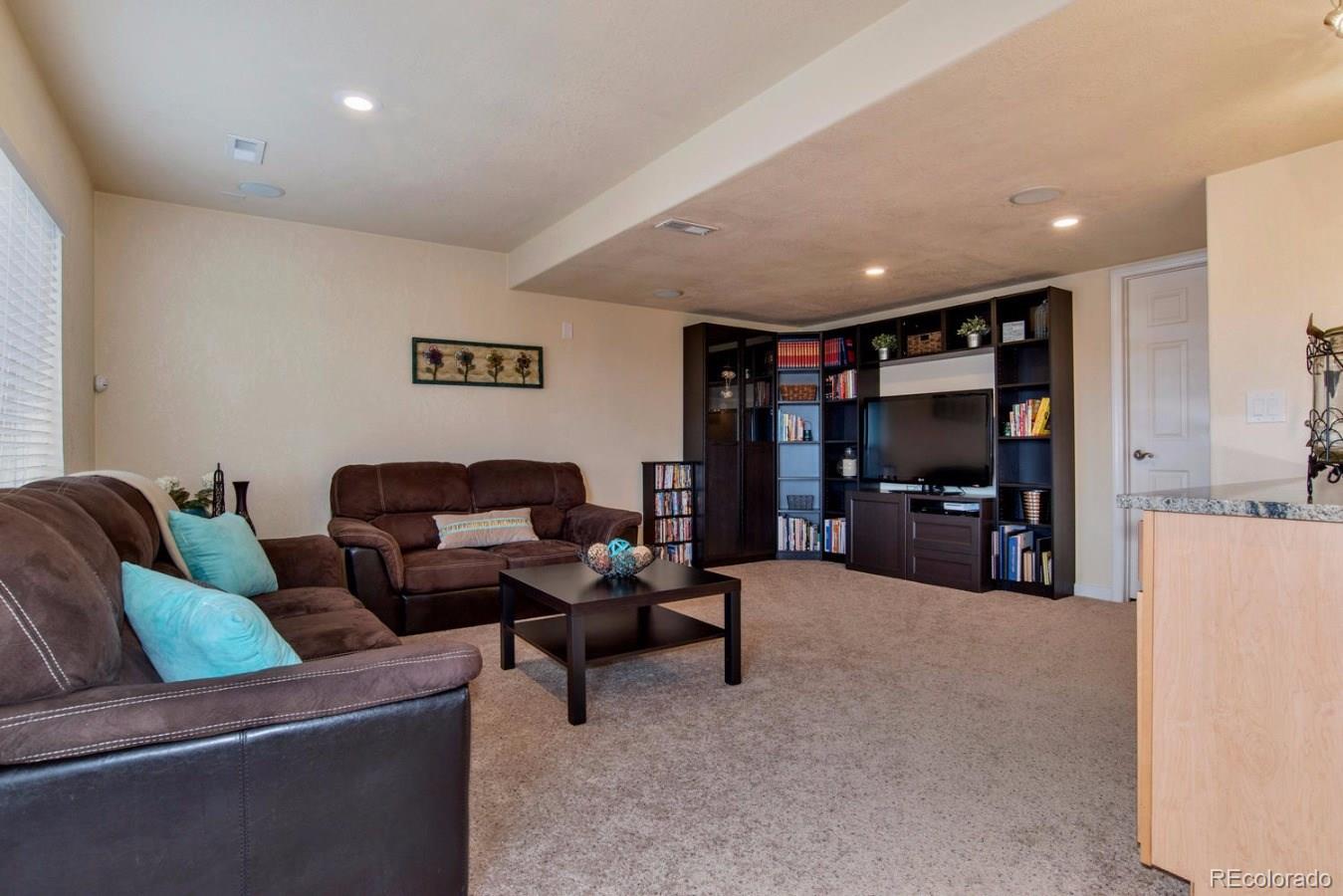 10232 Willowbridge Way Highlands Ranch, CO 80126 - Photo 10 of 33 a living room with furniture and a flat screen tv