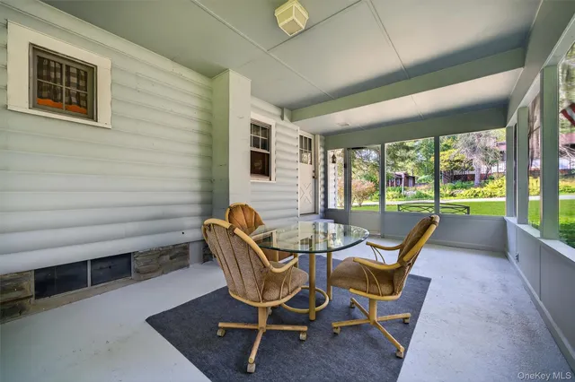a dining room with furniture and a floor to ceiling window