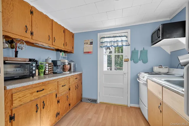 a kitchen with sink a microwave and cabinets
