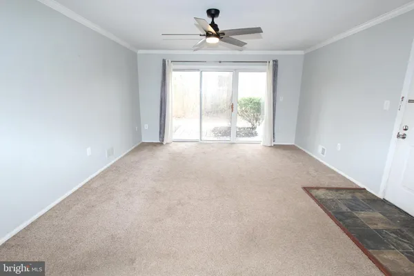 an empty room with windows and ceiling fan