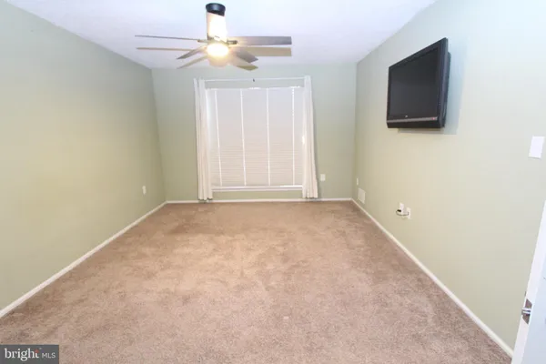 an empty room with windows and flat screen tv