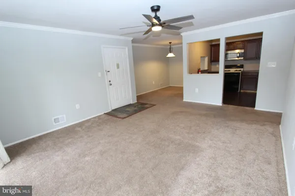 an empty room with closet and a ceiling fan