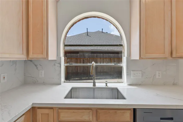 a large kitchen with stainless steel appliances granite countertop a sink a stove and a refrigerator