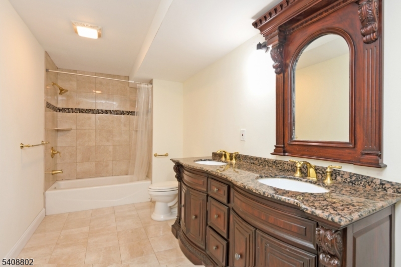 10 Raker Court Hillsborough, NJ 08844 - Photo 43 of 44 a bathroom with a granite countertop sink a mirror and a bathtub
