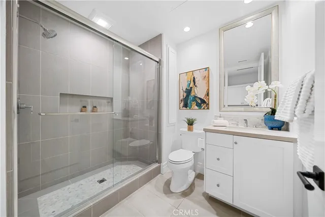 a bathroom with a granite countertop toilet sink and mirror