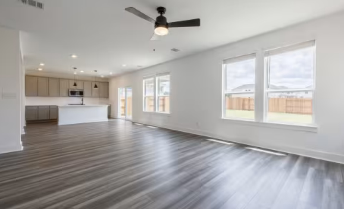 190 Prodigal Way Kyle, TX 78640 - Photo 2 of 14 a view of an empty room with a window and wooden floor