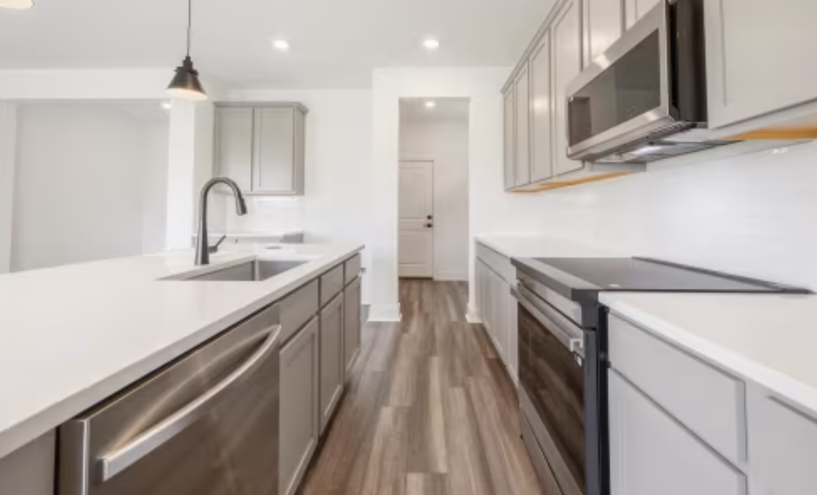 190 Prodigal Way Kyle, TX 78640 - Photo 3 of 14 a kitchen with a sink and a stove top oven with wooden floor