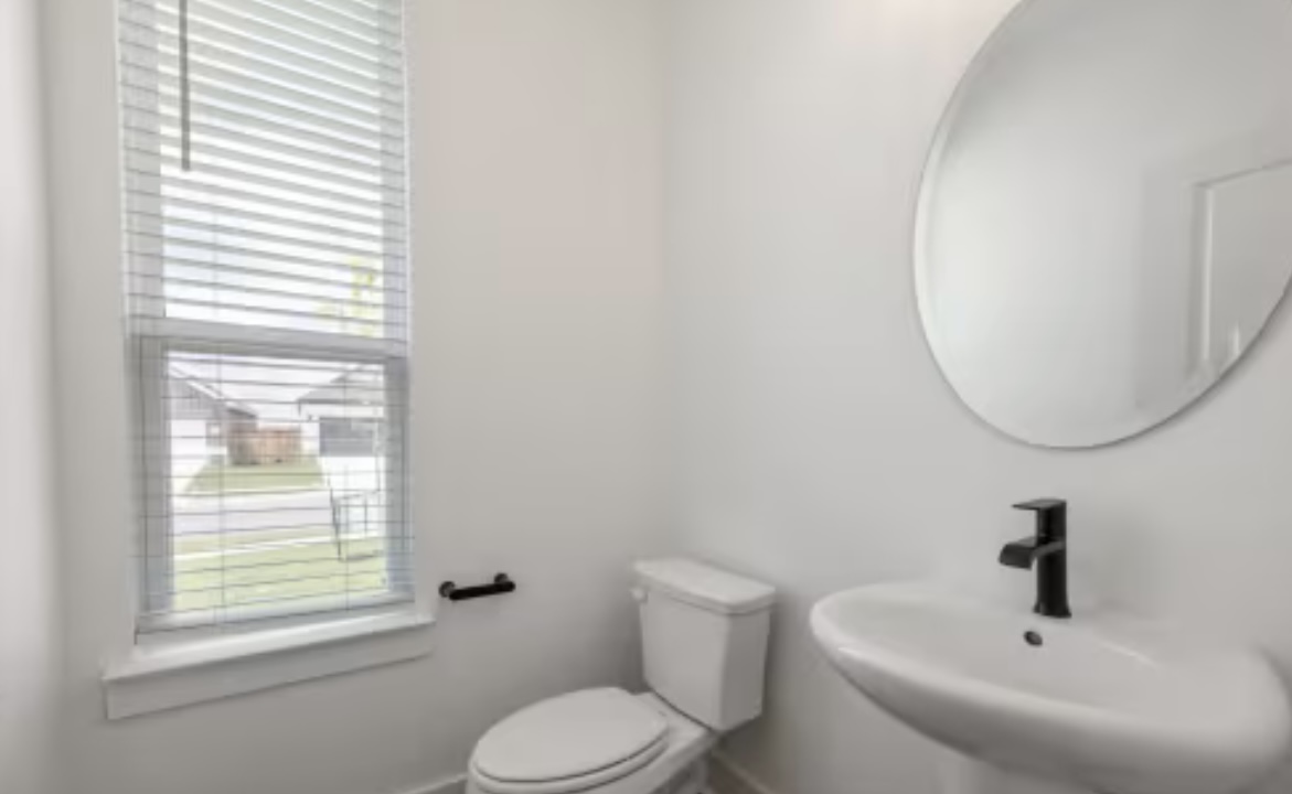 190 Prodigal Way Kyle, TX 78640 - Photo 5 of 14 a white toilet sitting next to a bathroom sink