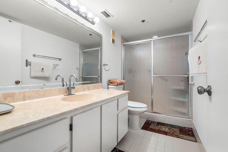 7310 Ashford Place, Unit 803 Delray Beach, FL 33446 - Photo 7 of 26 a bathroom with a sink a toilet and shower