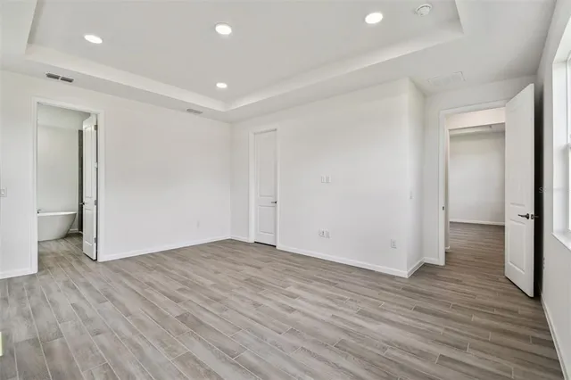 a view of empty room with wooden floor