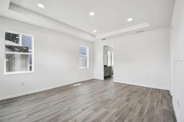 a view of empty room with wooden floor
