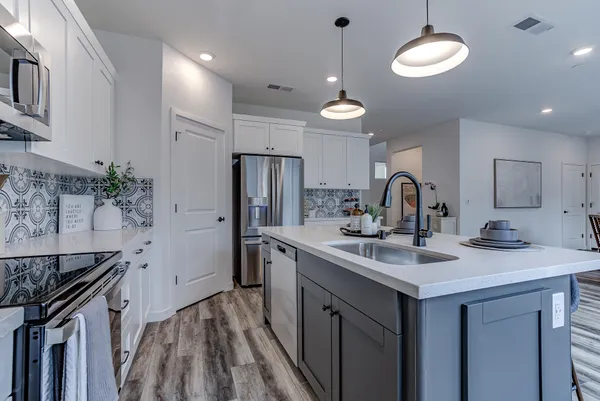 a kitchen with a sink stainless steel appliances a counter space and a center island