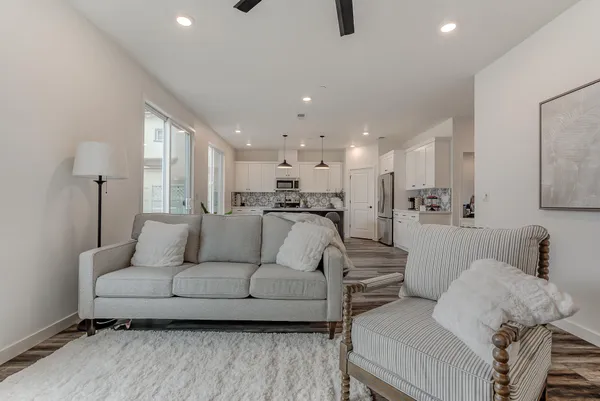 a living room with furniture and a view of kitchen