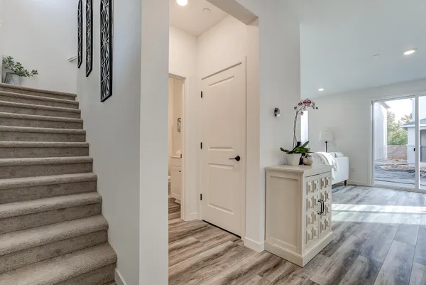 a view of a hallway with wooden floor and staircase