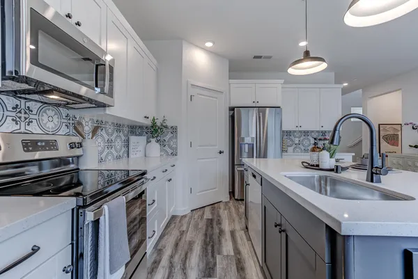 a kitchen that has a sink stainless steel appliances and cabinets