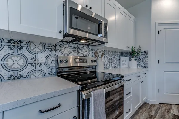 a kitchen with stainless steel appliances a stove a sink and cabinets