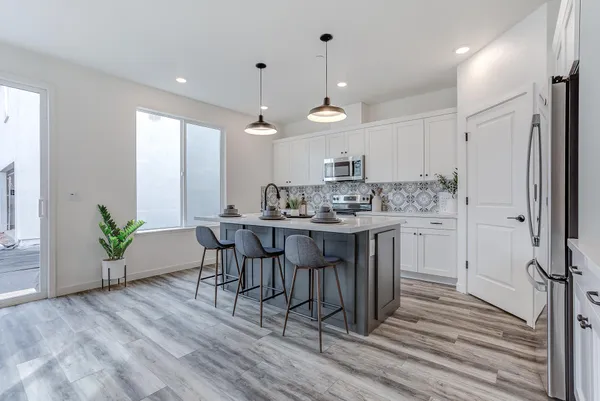 a kitchen with a table chairs refrigerator and microwave