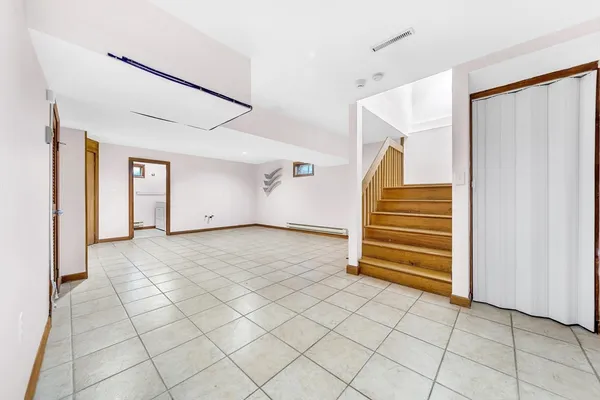 a view of empty room with stairs and white walls