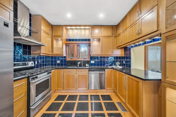 a kitchen with stainless steel appliances granite countertop a stove a sink and a microwave
