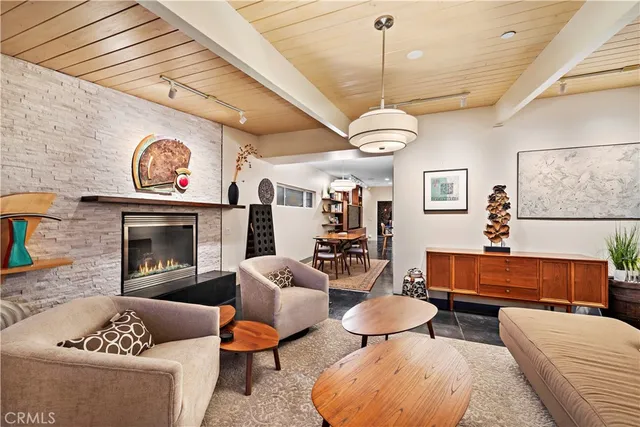 a living room with furniture a fireplace and a chandelier