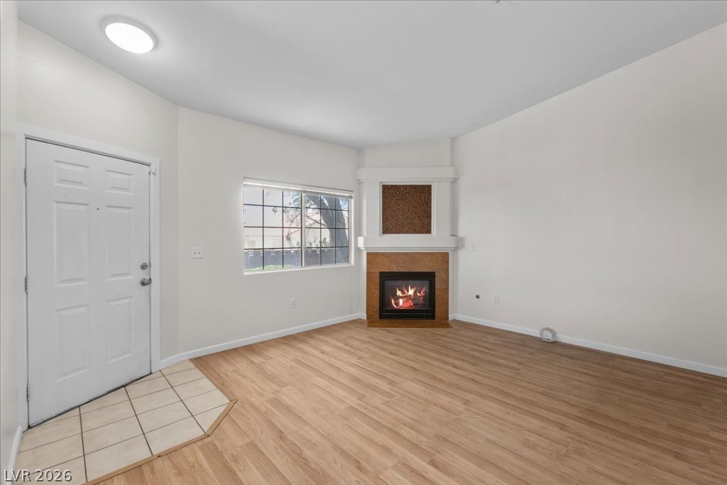 1881 West Alexander Road, Unit 1037 North Las Vegas, NV 89032 - Photo 8 of 31 A well-lit living area features a warm corner fireplace and durable wood flooring.