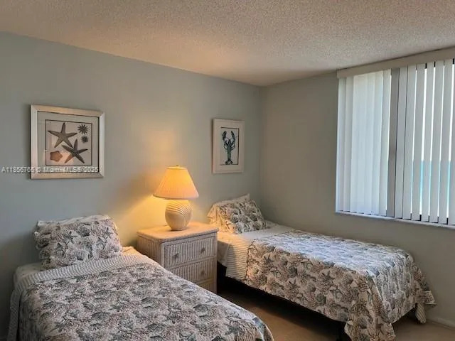 a bedroom with two beds and a chandelier