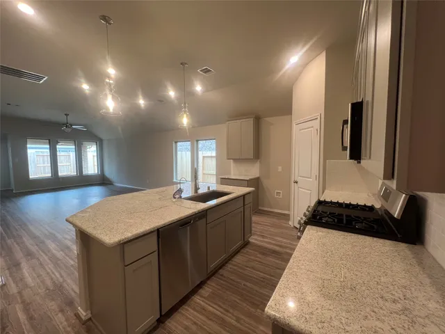 a kitchen with kitchen island a sink stainless steel appliances and cabinets