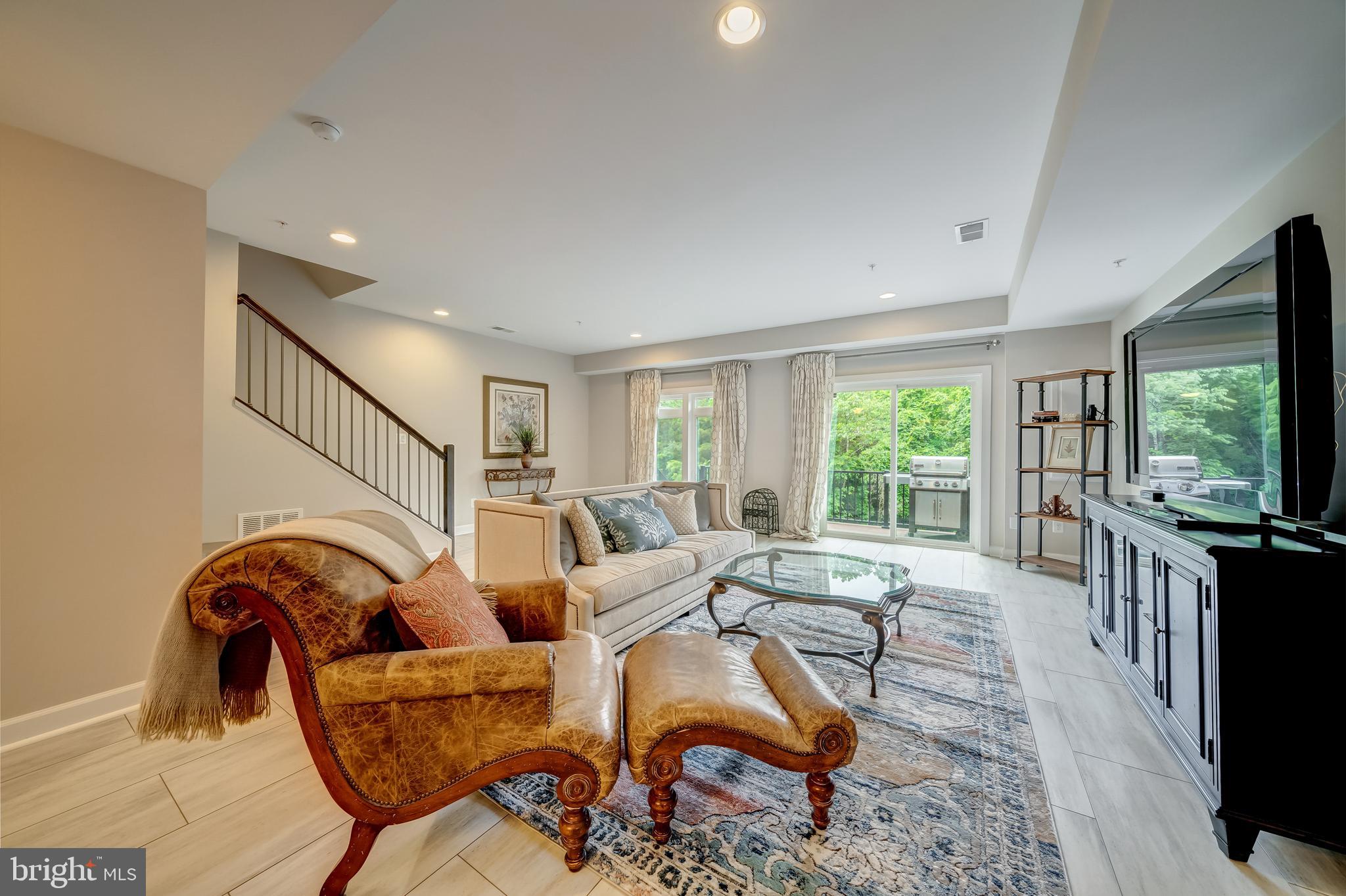 1521 Ribbon Limestone Terrace Southeast Leesburg, VA 20175 - Photo 11 of 34 a living room with furniture a flat screen tv and floor to ceiling window